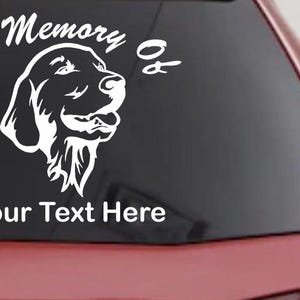 May include: White vinyl decal featuring a dog's head with the text "In Memory Of" and "Your Text Here". The decal is designed to be applied to a car window or similar surface. The dog's head is a detailed outline.