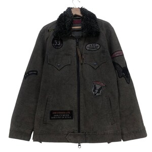 May include: A dark gray Levi Strauss & Co. jacket with a black faux fur collar. The jacket features multiple patches, including "53", "LSC Coffee Bar Cowboys", and a bulldog emblem. The text "QUALITY NEVER GOES OUT OF STYLE" is also visible.