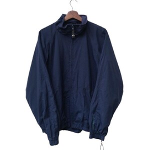 May include: A navy blue jacket with a high collar and a half-zip closure. The jacket is hanging on a wooden hanger. The sleeves are long, and the bottom hem is adjustable with a drawstring. The jacket appears to be made of a lightweight material.