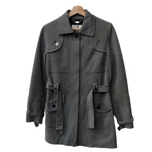May include: A gray, long-sleeved coat with a collared neckline and button closures. The coat features two front pockets with flaps, belt loops, and a matching belt. The coat is hanging on a wooden hanger.