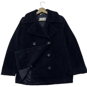 Puede incluir: Un abrigo de paño negro con diseño cruzado. El abrigo presenta un cuello con solapas, dos filas de botones y un bolsillo con solapa. La marca "Max Mara" es visible en la etiqueta.