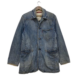 May include: A light blue denim jacket with a button-up front, two chest pockets, and two lower pockets. The jacket has a collar and long sleeves. The Levi's brand logo is visible on the chest pocket.