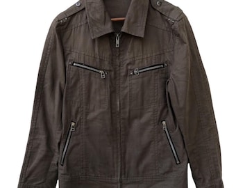 May include: A brown jacket with a collared neckline and multiple zippered pockets. The jacket is hanging on a wooden hanger. The jacket has a full-length zipper closure and decorative shoulder accents.