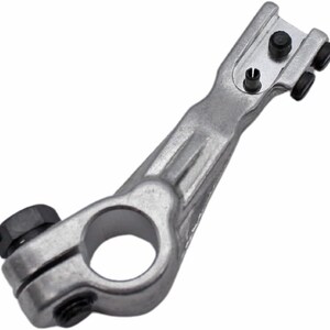 May include: A silver metal sewing machine foot with a round opening and a long arm. The foot has a small pin on the top and two black rubber rollers on the side.