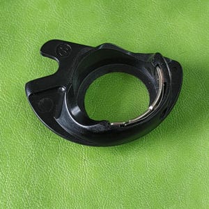 May include: Black plastic sewing machine bobbin winder with a silver metal spring.