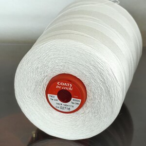 Puede incluir: Una bobina blanca de hilo Coats Tre Cerchi con una etiqueta roja. La etiqueta dice "Coats Tre Cerchi", "7802 Tid 030", "TRCR 19241178", "Col 02716", "5000m Tex 080".
