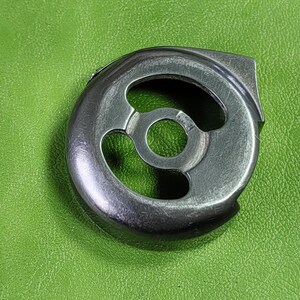 Può includere: Un porta bobina per macchina da cucire in metallo argentato con tre aperture circolari.
