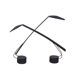 May include: Two black desk lamps with a minimalist design. Each lamp features a round base, a slender, curved arm, and a flat, leaf-shaped light fixture. The lamps are crossed, creating an X shape.