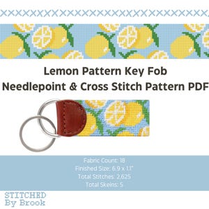 May include: A key fob with a lemon pattern, featuring a needlepoint and cross-stitch design. The key fob has a brown leather backing and silver key rings. The pattern includes yellow lemons on a light blue background. The text "Lemon Pattern Key Fob" is displayed.