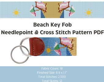 May include: A key fob with a needlepoint beach scene, featuring a blue sky, yellow sun, and beach umbrellas. The key fob has a brown leather backing and silver key rings. The text "Beach Key Fob" and "Needlepoint & Cross Stitch Pattern PDF" are visible.