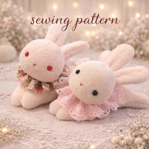 May include: Two plush pink bunny toys with floppy ears and decorative collars. One bunny has a floral collar, the other a lace collar. The text "sewing pattern" is written in a cursive font above the bunnies.