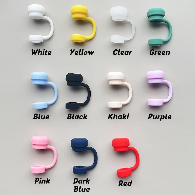 May include: A collection of colorful silicone straw covers in white, yellow, clear, green, blue, black, khaki, purple, pink, dark blue, and red. Each cover has a rounded top and a curved, U-shaped design with a small opening at the bottom. Text labels identify each color.