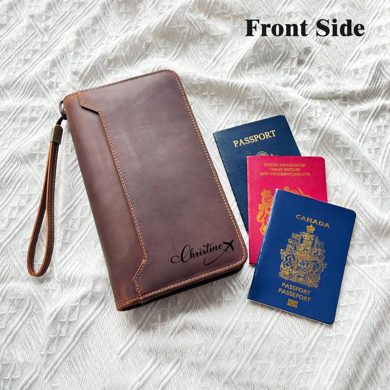 May include: A brown leather travel wallet with a wrist strap, personalized with the name "Christine X." Three passports are next to the wallet: blue, red, and blue. The text "Front Side" is at the top.