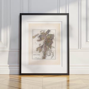 May include: Framed vintage map of Argyllshire, Scotland, featuring detailed cartography in shades of brown, green, and yellow. The map is set against a cream-colored background, encased in a black frame, and displayed against a white wall.