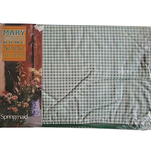May include: A twin flat sheet by Mary Emmerling Home, made of 100% cotton. The sheet is green and white gingham, packaged in plastic. The packaging features a floral design and the word "Springmaid".