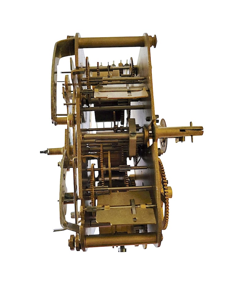 May include: A detailed view of a vintage clock mechanism, showcasing intricate brass gears, levers, and plates. The clock's internal workings are visible, highlighting the complexity of its design. The gears are various sizes and shapes.