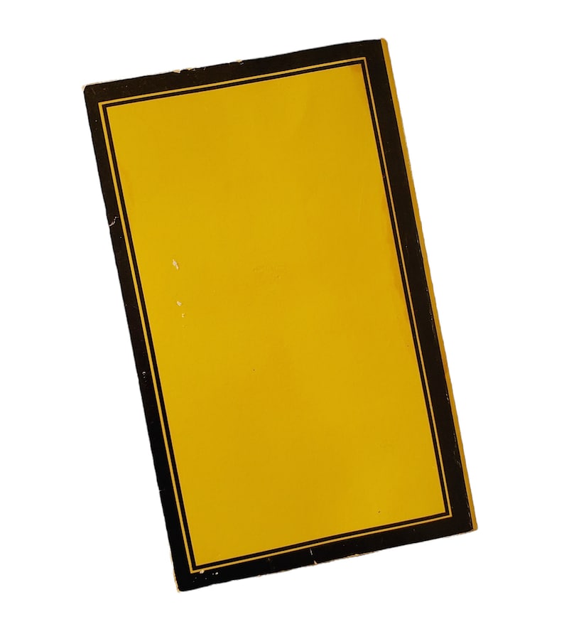 May include: A rectangular yellow object with a black border and a thin gold inner border. The object is slightly angled, showcasing its design against a white background. The yellow surface has a few small imperfections.