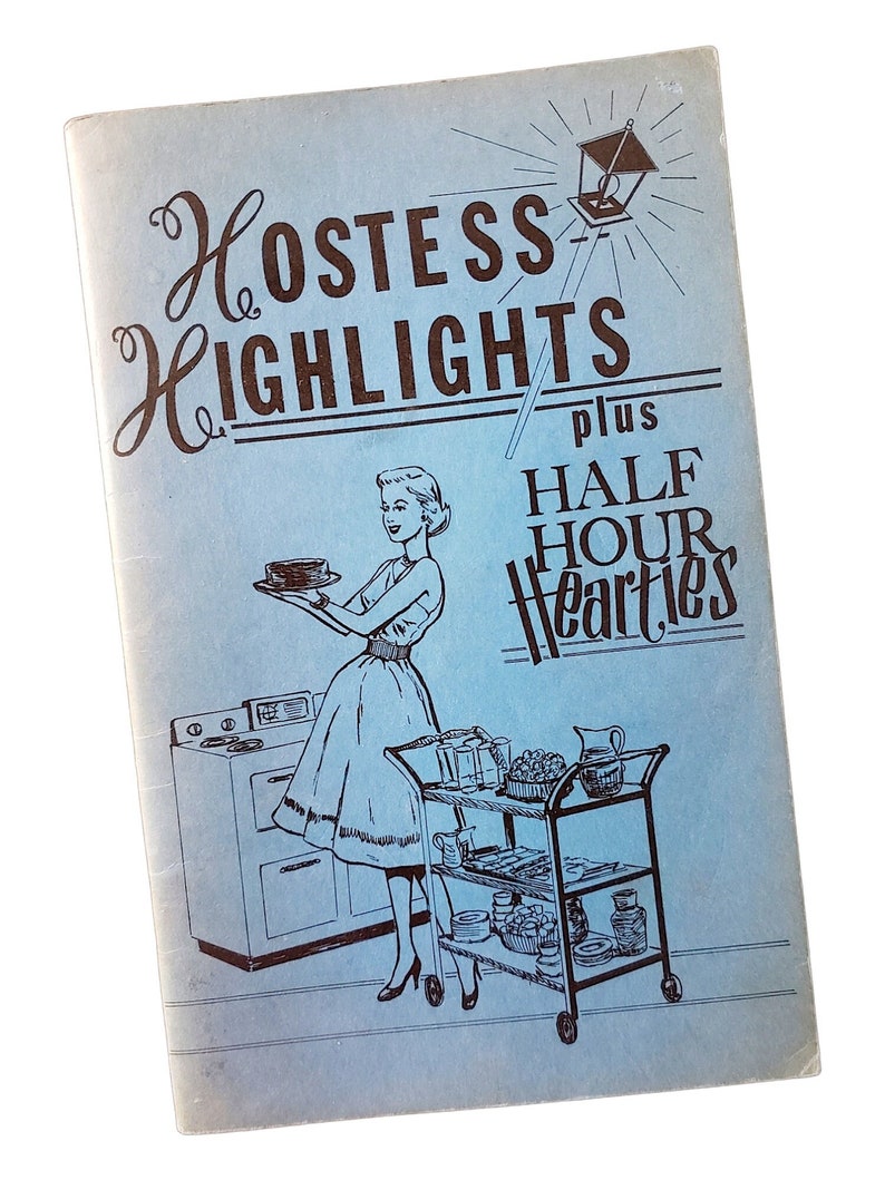 May include: A light blue vintage booklet cover titled Hostess Highlights plus Half Hour Hearties. The illustration features a person in a dress holding a cake near a stove and a three-tiered serving cart filled with various dishes and glassware.