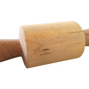 May include: A wooden rolling pin, featuring a cylindrical body and two rounded handles. The rolling pin is made of light-coloured wood and appears unused. This kitchen tool is used for rolling out dough for baking.
