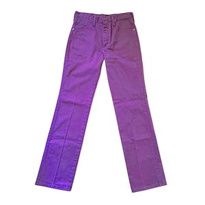 Puede incluir: Unos pantalones vaqueros de color morado s&oacute;lido con dise&ntilde;o de cintura alta, cierre de bot&oacute;n y cremallera, cinco bolsillos y perneras rectas con costuras verticales visibles a lo largo de la parte delantera de cada pierna, sobre fondo blanco.