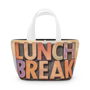 May include: A white tote bag with a black lining and a colorful wooden block design that says "Lunch Break".