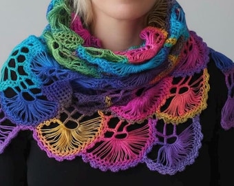 May include: A vibrant, hand-crocheted shawl in a spectrum of colors, including blue, green, pink, and purple. The shawl features an openwork design with a scalloped edge, creating a textured and eye-catching accessory. The color gradient adds depth and visual interest.