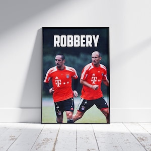 May include: A black and white poster featuring a photo of two footballers wearing red jerseys with the text "ROBBERY" at the top.