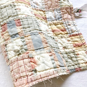 Rotolo di trapunte con motivi pastello, passatoia in tessuto trapuntato, accessori per diario