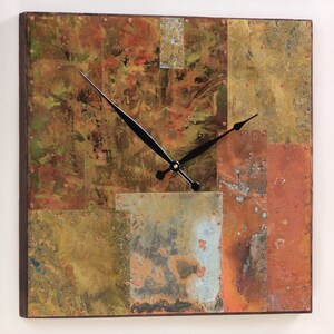 May include: Square wall clock with a distressed copper finish. The clock face is made of multiple pieces of copper that have been welded together. The clock hands are black.