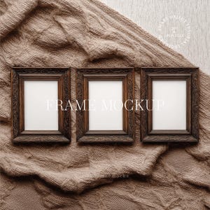 May include: Three dark brown wooden picture frames with ornate detailing, arranged on a textured, tan knitted blanket. The frames have white interiors and the text "FRAME MOCKUP" is displayed across the frames.