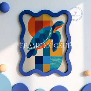 May include: A framed art print featuring a geometric turtle design in shades of blue, orange, and yellow. The artwork is set against a cream background and framed in a wavy, dark blue frame. The text "FRAME MOCKUP" is displayed on the artwork.