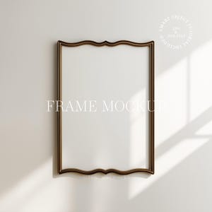 May include: A rectangular frame mockup with a dark brown, ornate border. The frame has a scalloped top and bottom edge. The text "FRAME MOCKUP" is centered in the frame. The background is a light beige colour.