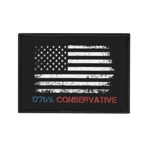 May include: A rectangular black patch featuring a distressed white American flag graphic. Below the flag, the text 1776% CONSERVATIVE is printed in a stencil-style font, with 1776% in blue and CONSERVATIVE in red, all bordered by black stitching.