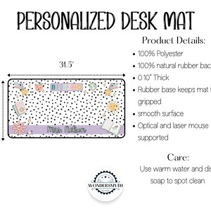 Op de afbeelding: Gepersonaliseerde bureaumat met een zwart-wit polkadotpatroon. De mat heeft kleurrijke illustraties van een zon, sterren, boeken en bloemen. De tekst "BE KIND" wordt weergegeven, samen met de naam "Mrs. Nelson". De mat meet 80 cm bij 39 cm.