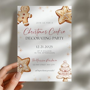 May include: A white invitation card with watercolor illustrations of gingerbread cookies and a Christmas tree. The text reads "Christmas Cookie Decorating Party" with the date and time. The card is held by a hand.