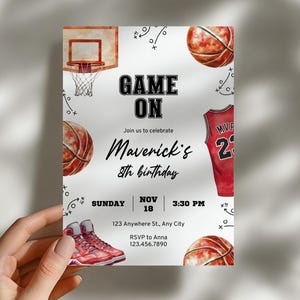 Könnte beinhalten: Basketball-Geburtstagseinladung mit den Worten "GAME ON" und "Maverick's 8. Geburtstag". Die Einladung zeigt Basketbälle, ein Trikot, einen Basketballkorb und Turnschuhe. Das Datum ist der 18. November um 15:30 Uhr.