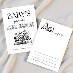 Puede incluir: Dos tarjetas blancas con texto negro. Una dice "BABY'S first ABC BOOK" con una ilustraci&oacute;n floral. La otra tarjeta dice "Aa is for" con l&iacute;neas debajo. Ambas tarjetas tienen el texto "made with love by family bfa".