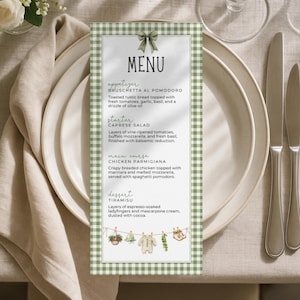 May include: A menu card with a green gingham border and a decorative bow at the top. The menu lists appetizers, a starter, a main course, and dessert. The menu is set on a table with plates, silverware, and a floral arrangement.