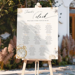 Puede incluir: Un plano de asientos de boda crema sobre un caballete de madera. El letrero tiene detalles dorados y el texto "Janet's Officially Off the Clock, Please Find Your Seat". Un gráfico de reloj dorado en la parte inferior.