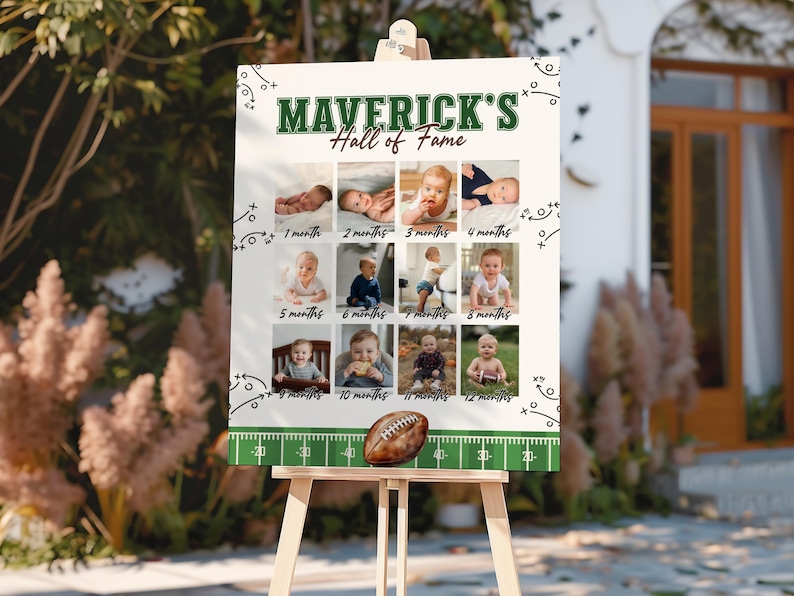 May include: A white sign on an easel with the text "MAVERICK'S Hall of Fame" in green. The sign displays 12 baby photos, each labeled with a month. A football sits at the bottom of the sign.