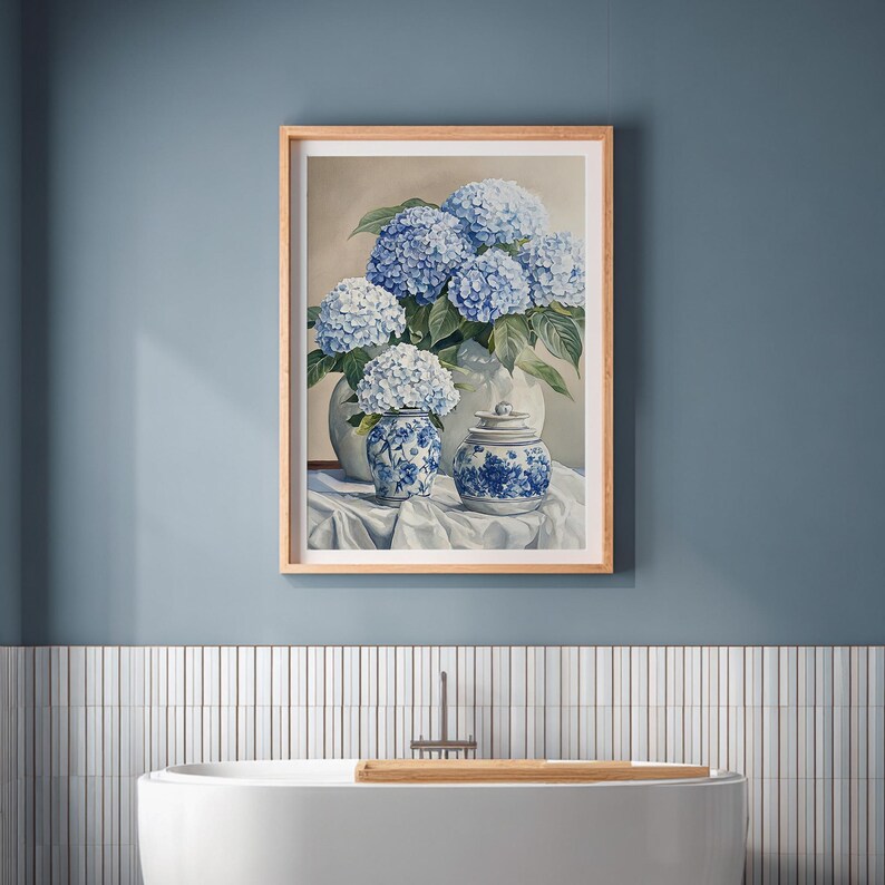 Blue hydrangea wall art featuring hydrangeas in ginger jars, displayed above modern bathtub in coastal style bathroom with wood accents. French farmhouse hydrangea artwork with grandmillennial art influence, styled as wall decoration.