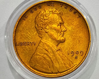 May include: A gold-colored 1909 S Lincoln cent coin, encased in a clear plastic holder. The coin features a profile of Abraham Lincoln, with the words "IN GOD WE TRUST" and "LIBERTY" visible.