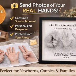 May include: A framed black and white print with the text "Our First Game as a Family" and "The Smiths Family Est. 2023". The image shows handprints in a rock, paper, scissors formation. The image also shows a print of hands and the text "Send Photos of Your Real Hands!"