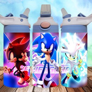Puede incluir: Tres botellas de agua azules con diferentes personajes de Sonic the Hedgehog. Las botellas tienen una tapa blanca y una pajita. Los personajes son Sonic, Shadow y Silver.