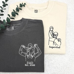 a couple of t - shirts sitting on top of a white towel