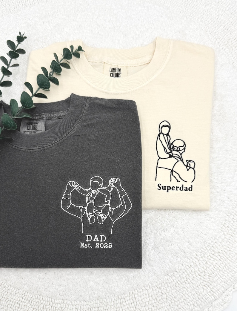 a couple of t - shirts sitting on top of a white towel