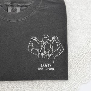 a t - shirt with a picture of a man lifting a barbell