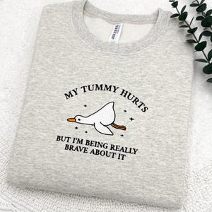 a t - shirt that says, my tummy hurts but i'm being