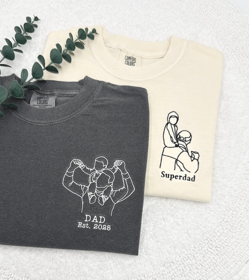 a couple of t - shirts sitting on top of a white towel