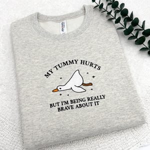 a t - shirt that says, my tummy hurts but i'm being